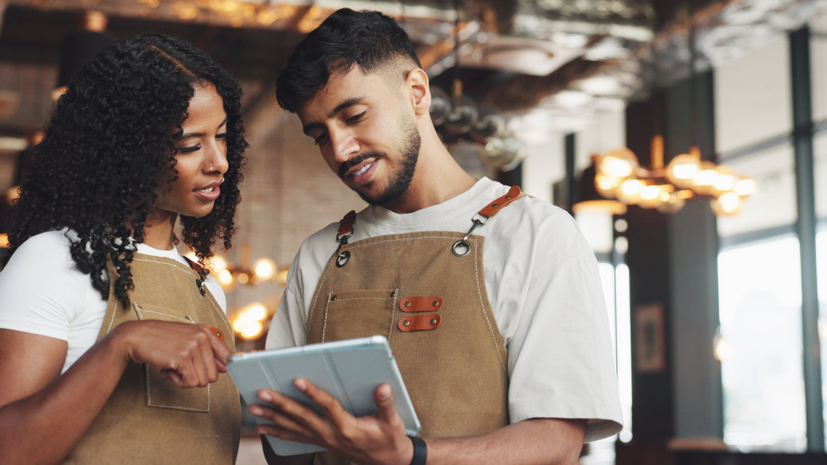 Two young people in a shop checking the transactions on the ipad