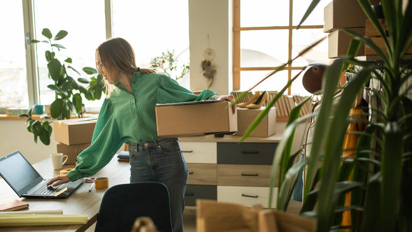 Female entrepreneur fulfilling online orders in bright boutique workspace