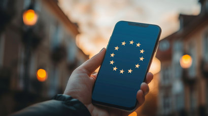 A phone in the hand, with european union flag in the whole background