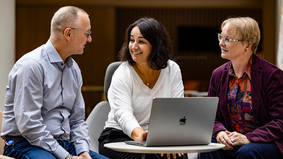 A man and two woman sitting together, engaged in a conversation