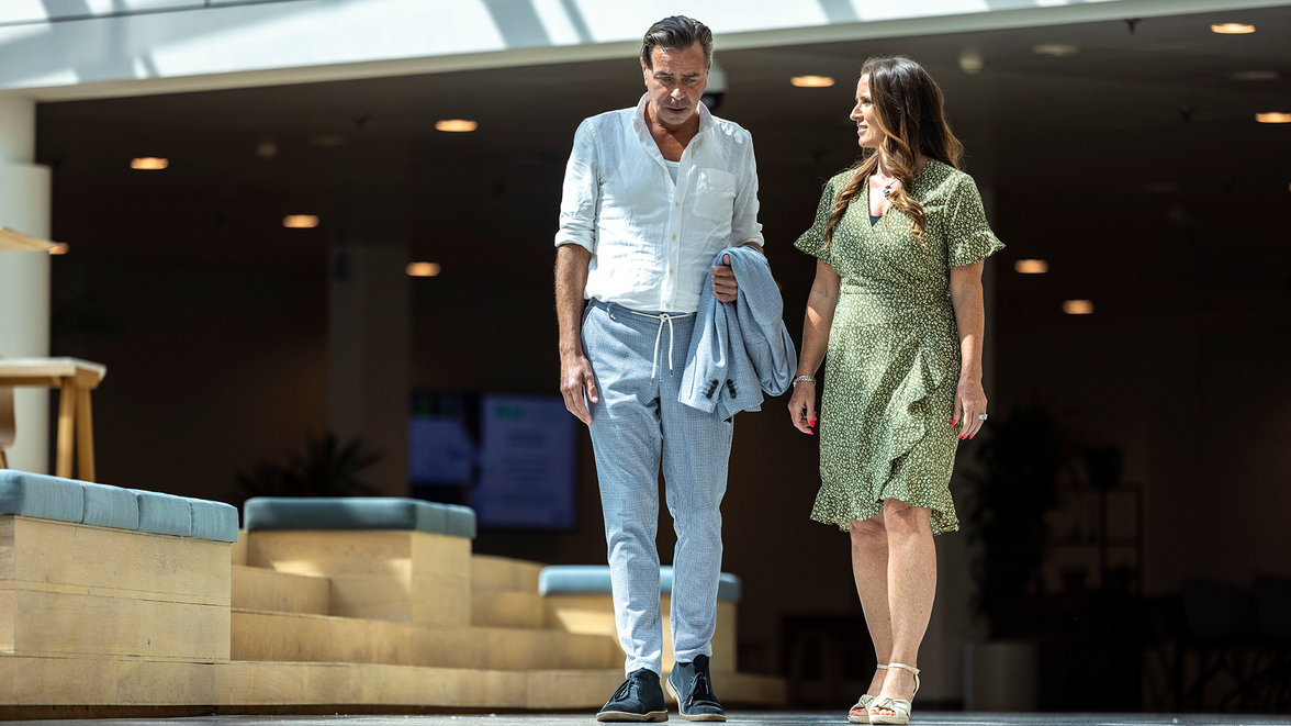 A man and woman walking side by side, engaged in conversation