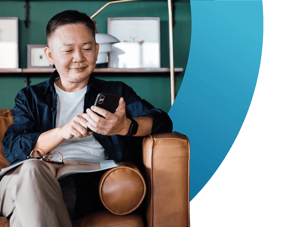 senior asian man using smartphone while relaxing on the sofa