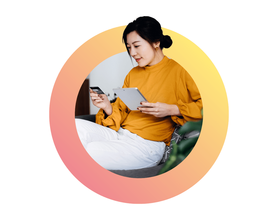 beautiful smiling young asian woman sitting on sofa in the living room managing online banking handling bank account and financial bills with digital tablet
