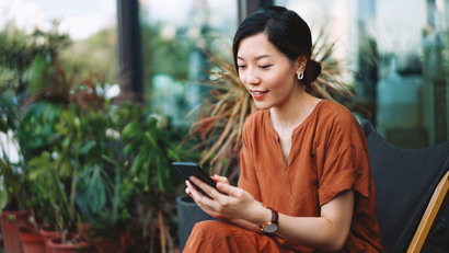 Cheerful young asian woman using smartphone
