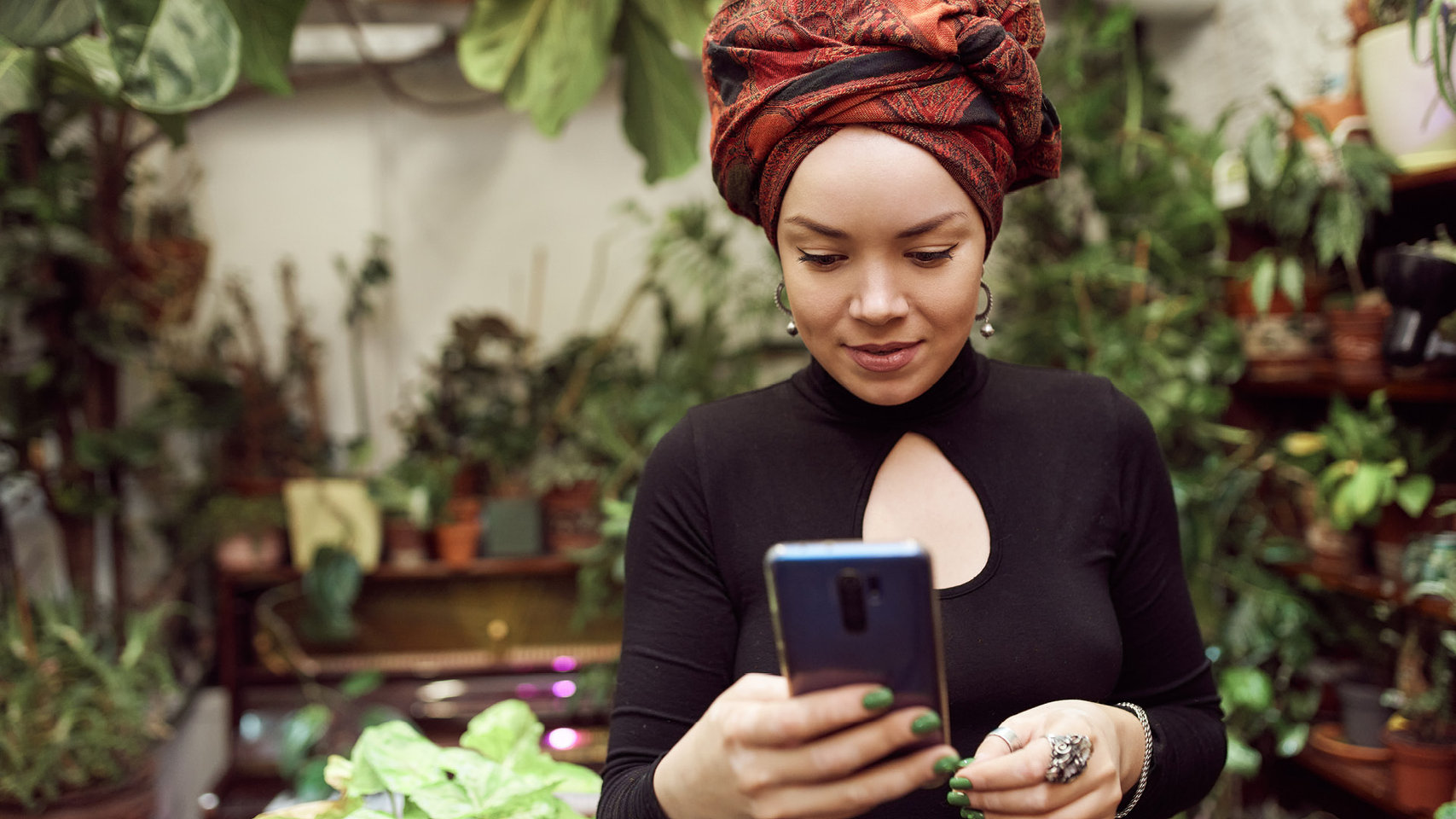 woman-browsing-smartphone-in-greenhouse