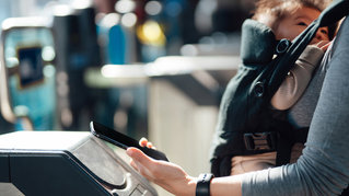 woman-making-contactless-payment-for-train-ticket-with-smart-phone-at-underground-station