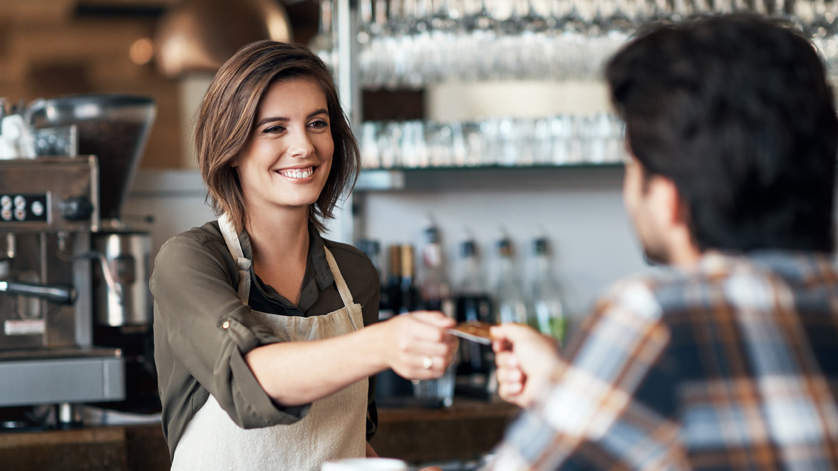 female bartender receives card from male customer