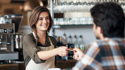 img-full-female-bartender-receiving-a-card-as-payment-from-a-customer-inside-of-a-restaurant