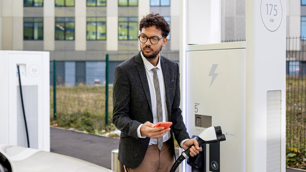 img-full-man-in business-dress-stood-at-an-electric-charging-station
