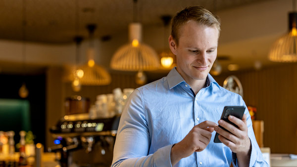 man in restaurant looking at the phone