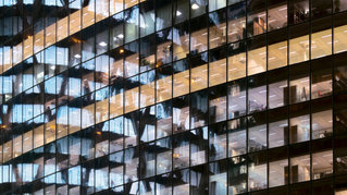 Reflections in glass office facade at dusk