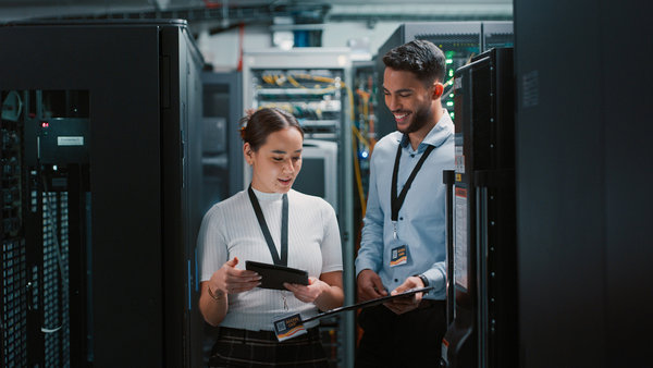 full shot of two collegues working together in a server room