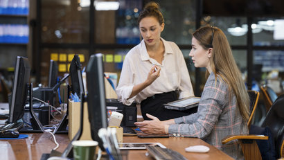 two employees looking at the screen at an office setting