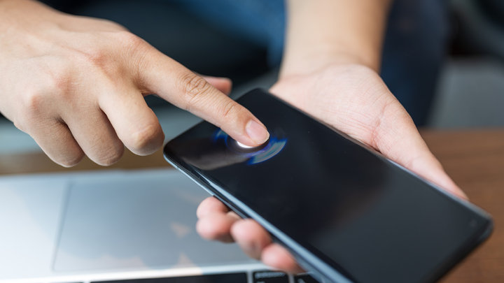 closeup view of a person using their fingerprint to unlock their phone