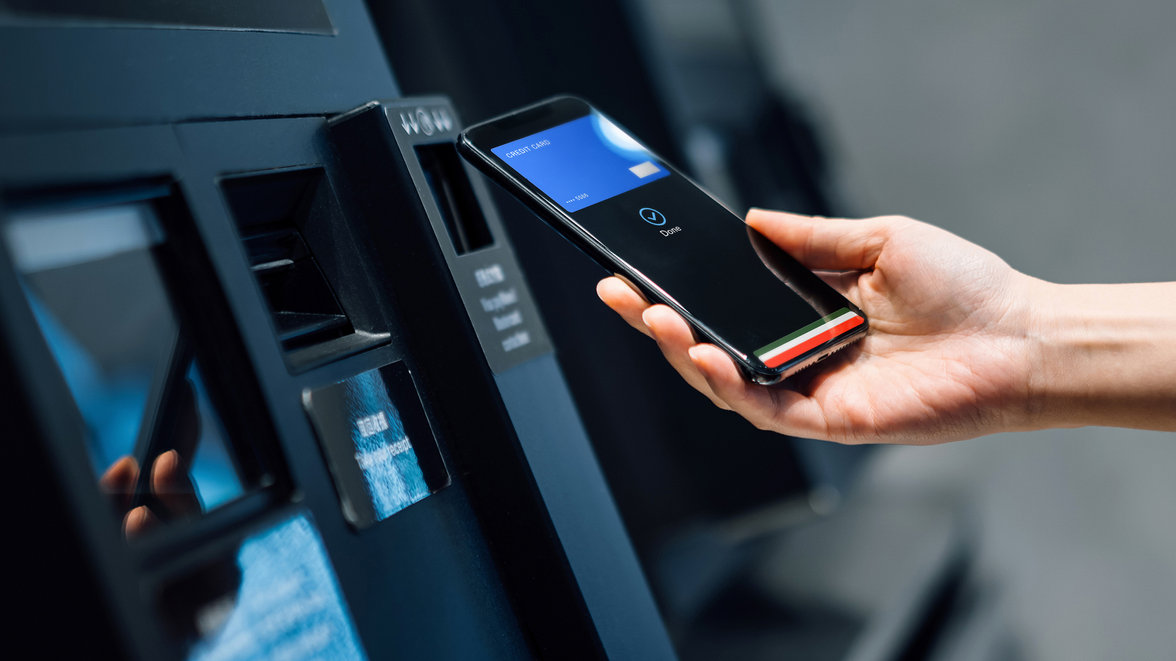 Woman using contactless payment smartphone to pay for shopping at self checkout kiosk - What payment innovation means for the payments landscape