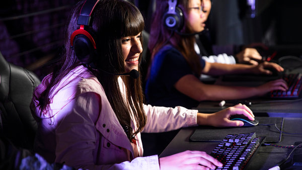 full young college students playing esports at computer stations