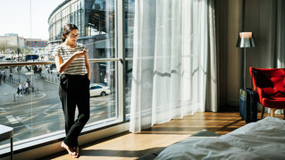 woman checking mobile phone in a hotel room