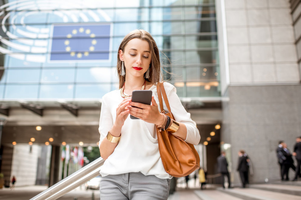 woman checking mobile phone in from of office