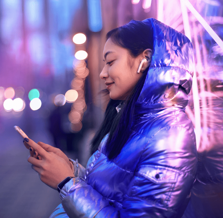 woman using smartphone in neon lit city