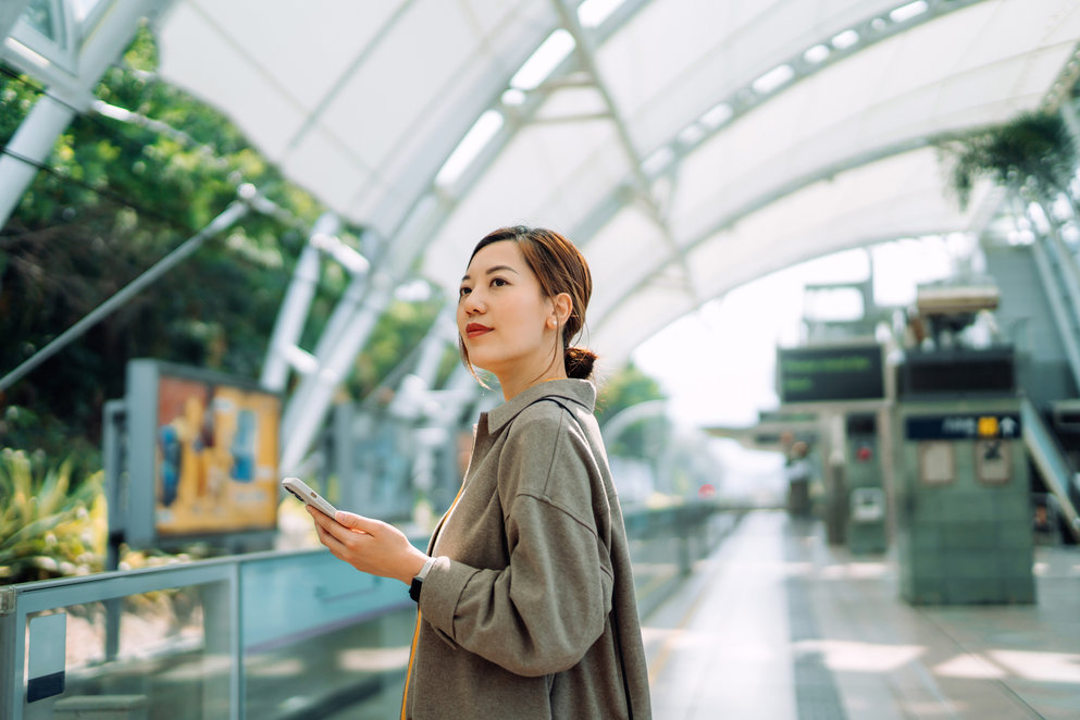 img-woman-with-a-smartphone-at-a-train-station