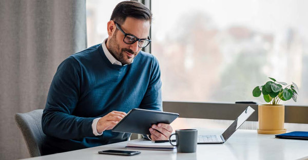 man working on this tablet at the office desk