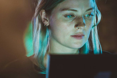 woman looking at a computer screen in a dark environment