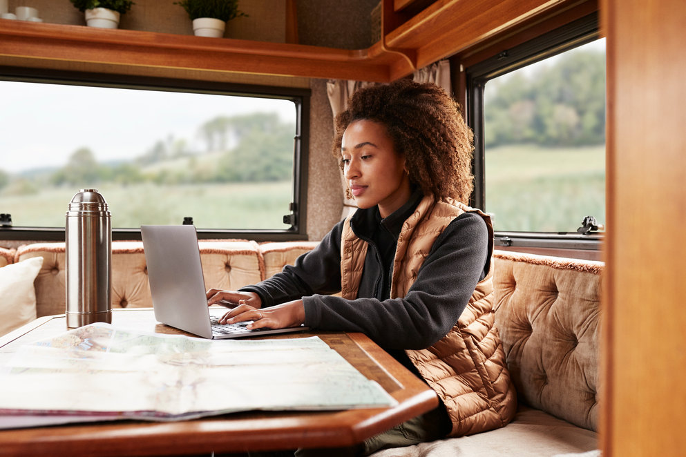 Woman using laptop in camper van