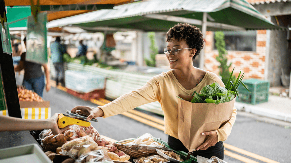 woman paying with her phone at a market