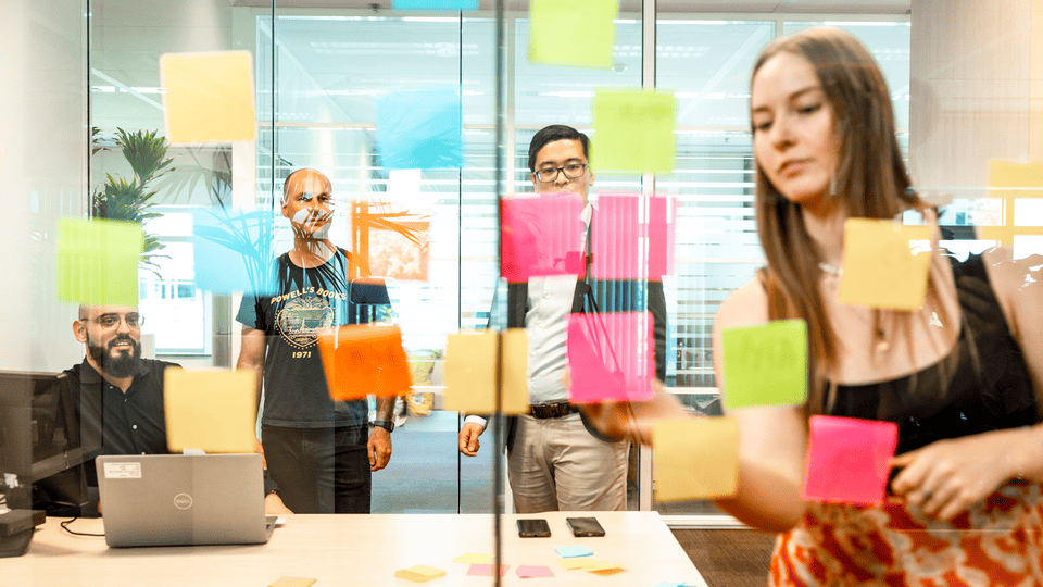 Coworkers brainstorm with post-ins in a meeting room