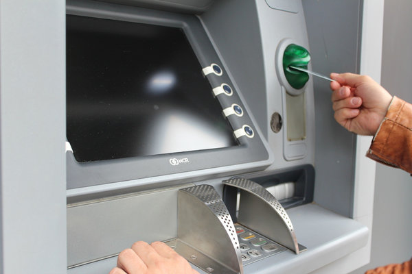 man hand inserting a card in an ATM