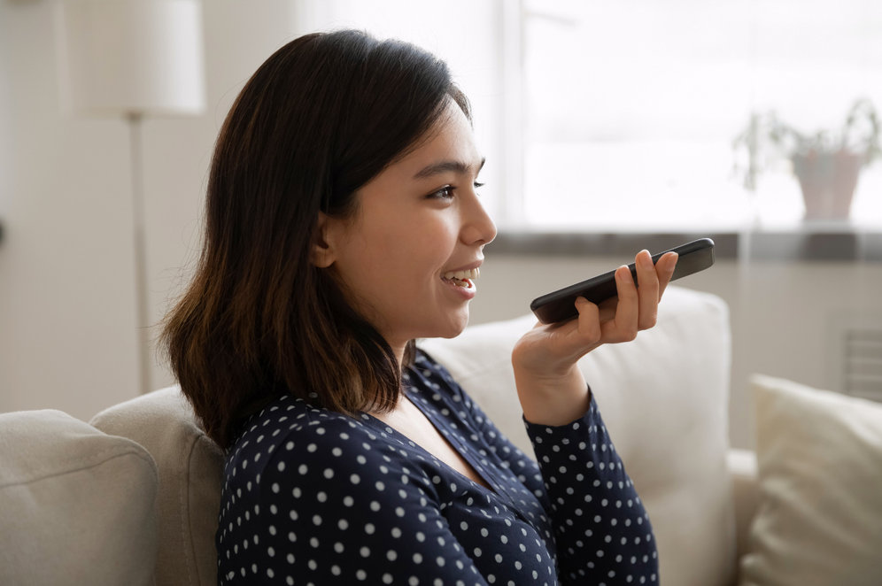 woman holding a phone in her hand and speaking into it