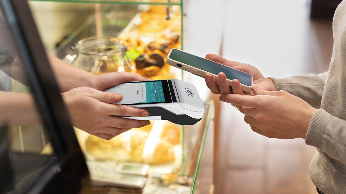 Person paying with their phone on a Payment Terminal