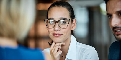 a woman wearing glasses looking at another woman