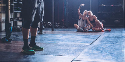 2 woman at the gym taking a selfie sitted on the floor