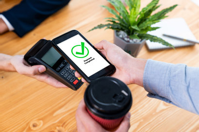 A woman paying with her smartphone at a restaurant