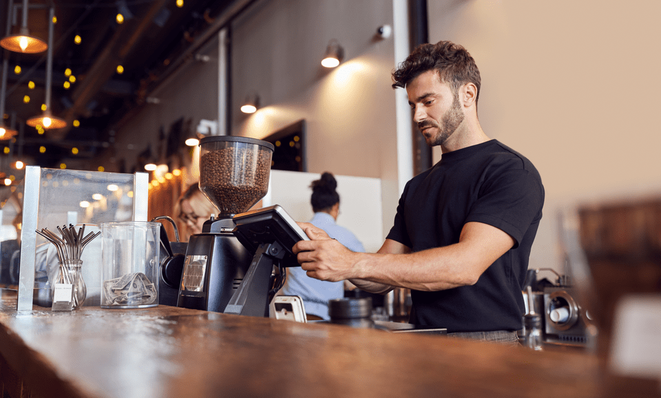 male barista using a order machine