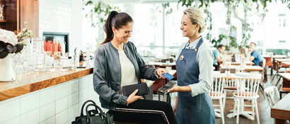 an employee handing out a card machine to a customer