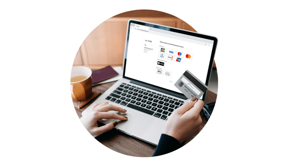 Bild på en laptop med en persons händer som betalar med sitt kort i en webbshop