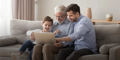 Ett barn, hans pappa och farfar sitter tillsammans och tittar på en Ipad