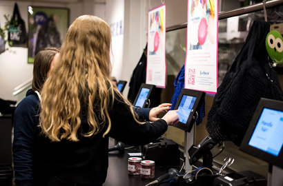 2 women in a shop, paying at a self-checkout counter